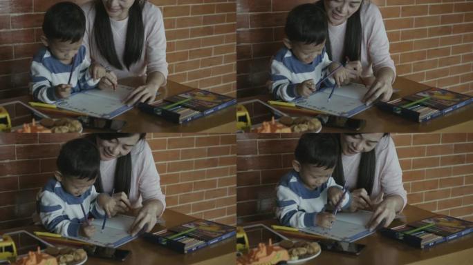 亚洲单亲妈妈和儿子的4k慢动作镜头在现代阁楼房屋中微笑着充满幸福的生活，以实现自我学习或家庭学校，家