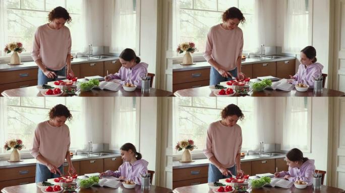 妈妈准备蔬菜沙拉，而十几岁的女儿在厨房学习