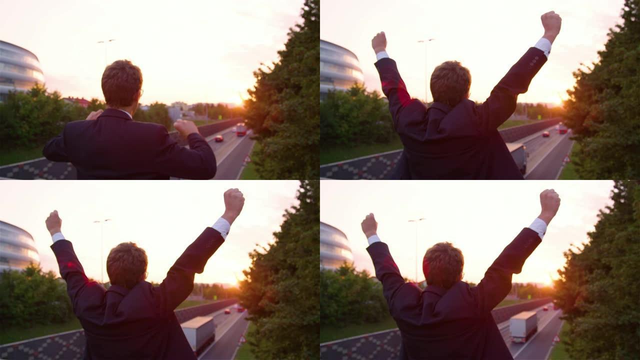 特写: 兴奋的经理在观看日出时举起手臂。