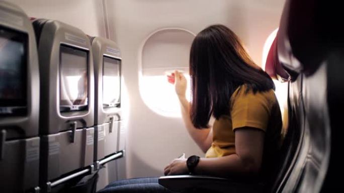 女乘客打开飞机机舱的窗户，慢动作
