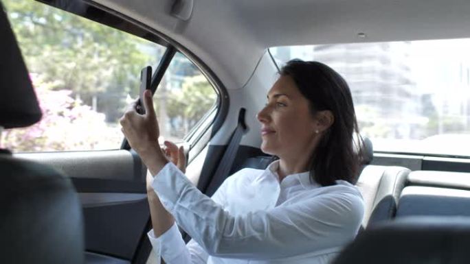 汽车上的女商人摄影智能手机