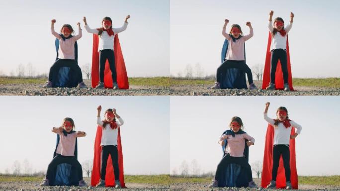 两个有趣的小女孩姐妹打扮成超级英雄的真实镜头，穿着红色和蓝色的舞蹈，玩得开心