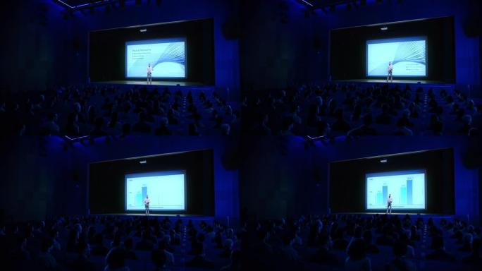 舞台上的扬声器向观众致意，展示技术产品，使用遥控器进行演示，在大屏幕上显示信息图表，统计动画。现场活