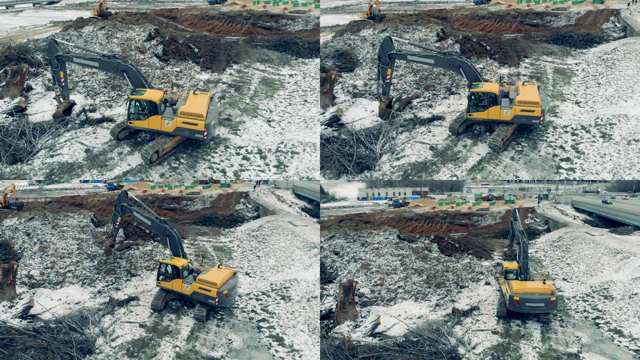 黄色挖掘机在采石场用石头工作。