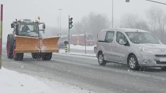 慢动作: 带扫雪机的拖拉机和汽车沿着雪道行驶。