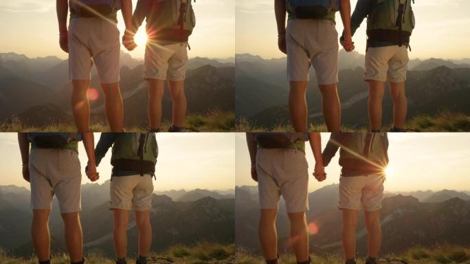 在山上观察日落时，亲密的女人和男人牵着手