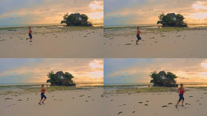 日落时，SLO MO女人沿着米汉维平韦海滩慢跑