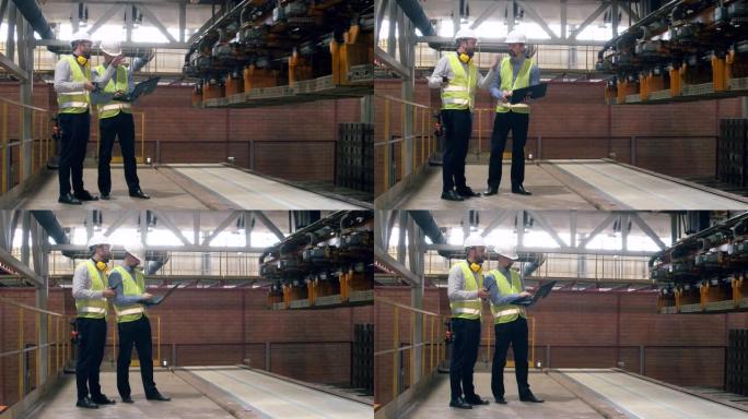 工厂工人检查移动砖块的机器。