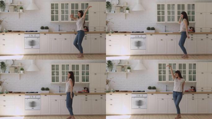 快乐无忧无虑活泼的女孩独自在现代厨房内部跳舞