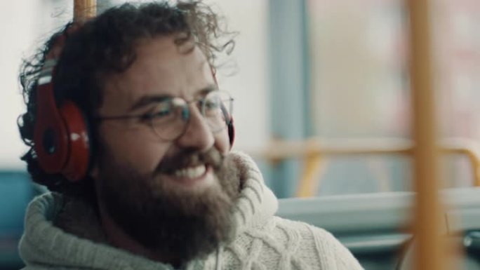 微笑的男人在公共汽车上听音乐