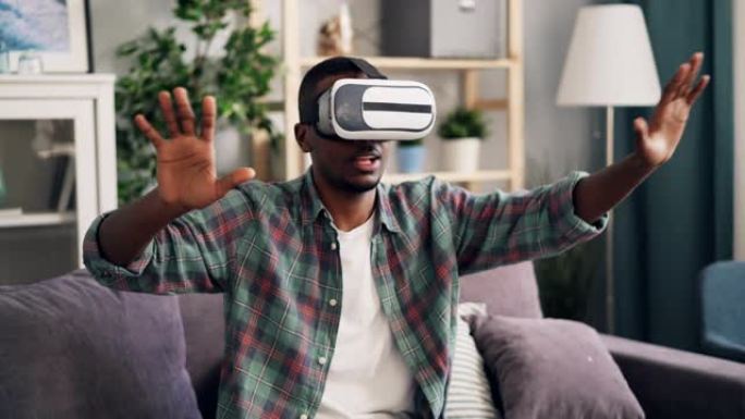 年轻人使用虚拟现实眼镜玩得开心，坐在家里的沙发上