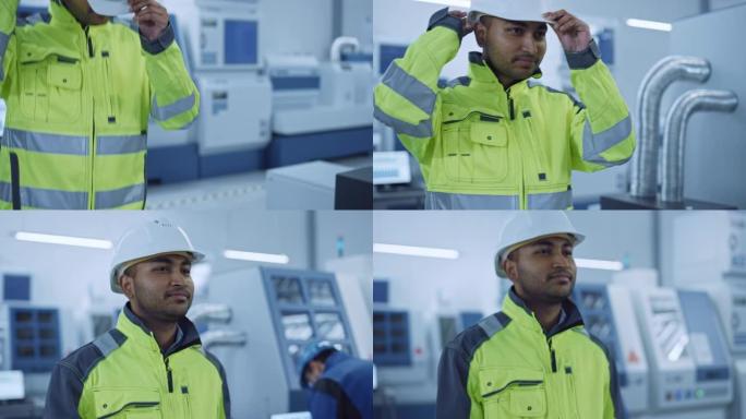 工业4工厂: 一名穿着安全夹克的现代工人的肖像戴上安全帽，走过当代工业车间，专业人员在那里工作和编程