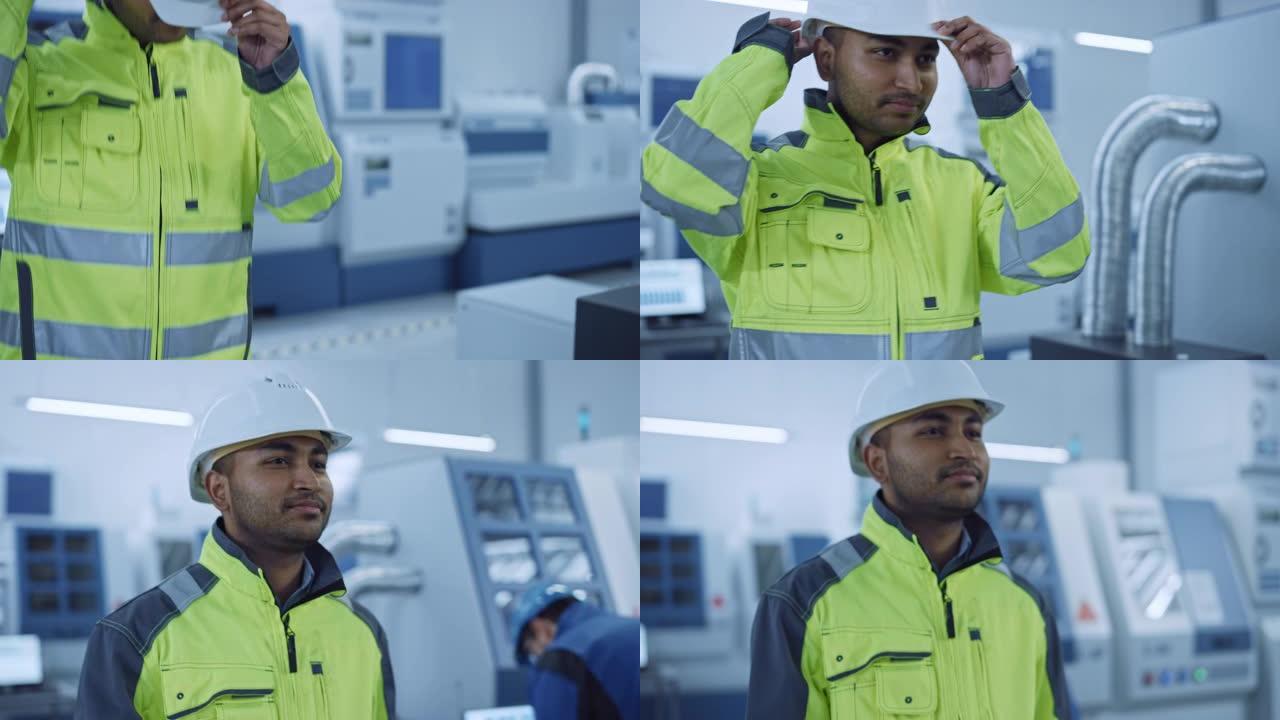 工业4工厂: 一名穿着安全夹克的现代工人的肖像戴上安全帽，走过当代工业车间，专业人员在那里工作和编程