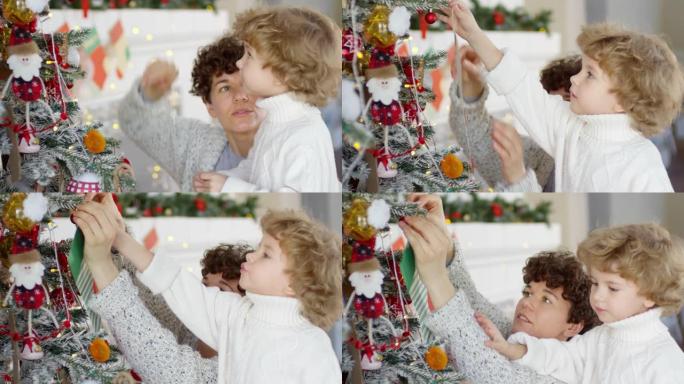 小男孩和他的母亲在圣诞树上装饰