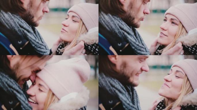 快乐微笑的欧洲年轻浪漫夫妇的特写镜头站在一起，在寒冷的日子里在外面聊天。