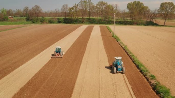 农业拖拉机的航拍正在耕种和耕种田地，以备将来在晴天播种新作物