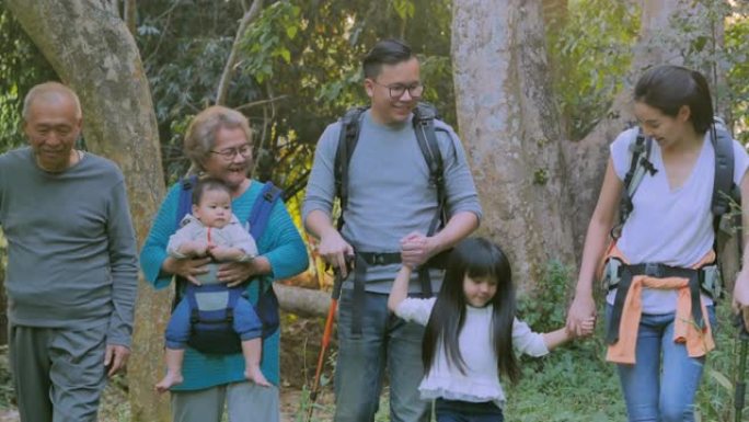 快乐的亚洲大家庭在露营中散步，教孩子们关于森林的可持续性。快乐的家庭在户外共度时光。教孩子们关于可持