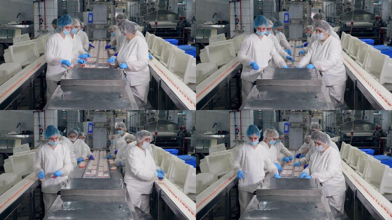 工厂工人将产品包装到工厂的塑料容器中。