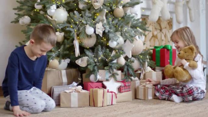 小孩子跑到圣诞树前拿礼物
