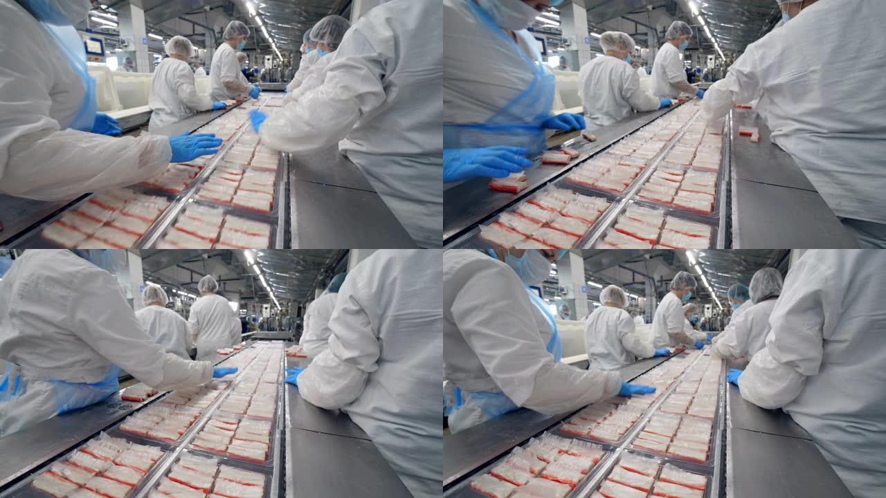 食品厂工人从移动生产线包装产品。