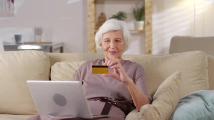 老年妇女在笔记本电脑上在线购物