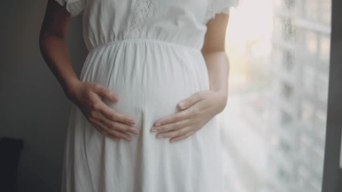怀孕/出生抚摸自己的肚子白色连衣裙