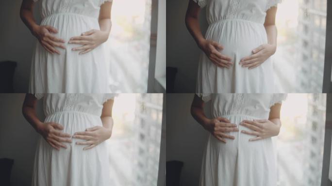 怀孕/出生抚摸自己的肚子白色连衣裙