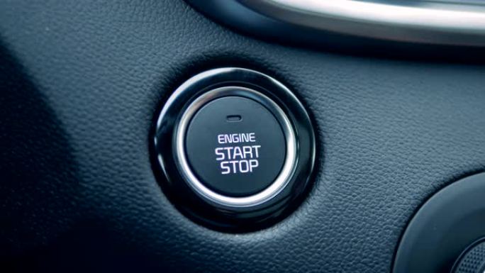 手指在汽车上按下启动和停止按钮