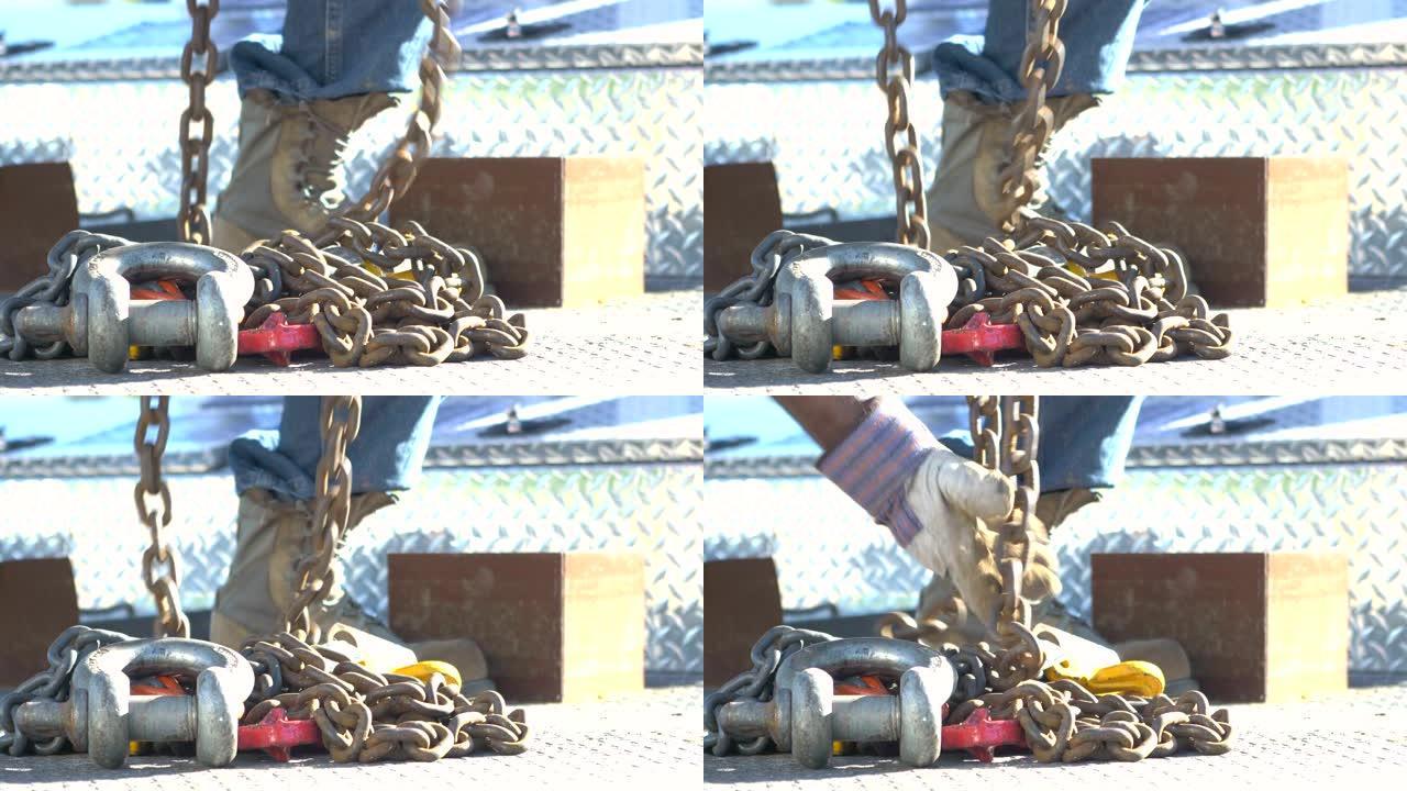 起重机上的建筑工人拿起吊钩和链条