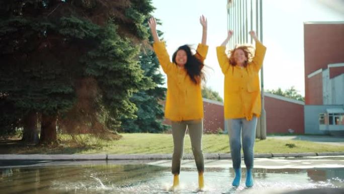 快乐的年轻女性在水坑里跳进户外的肖像，举起手臂玩得开心