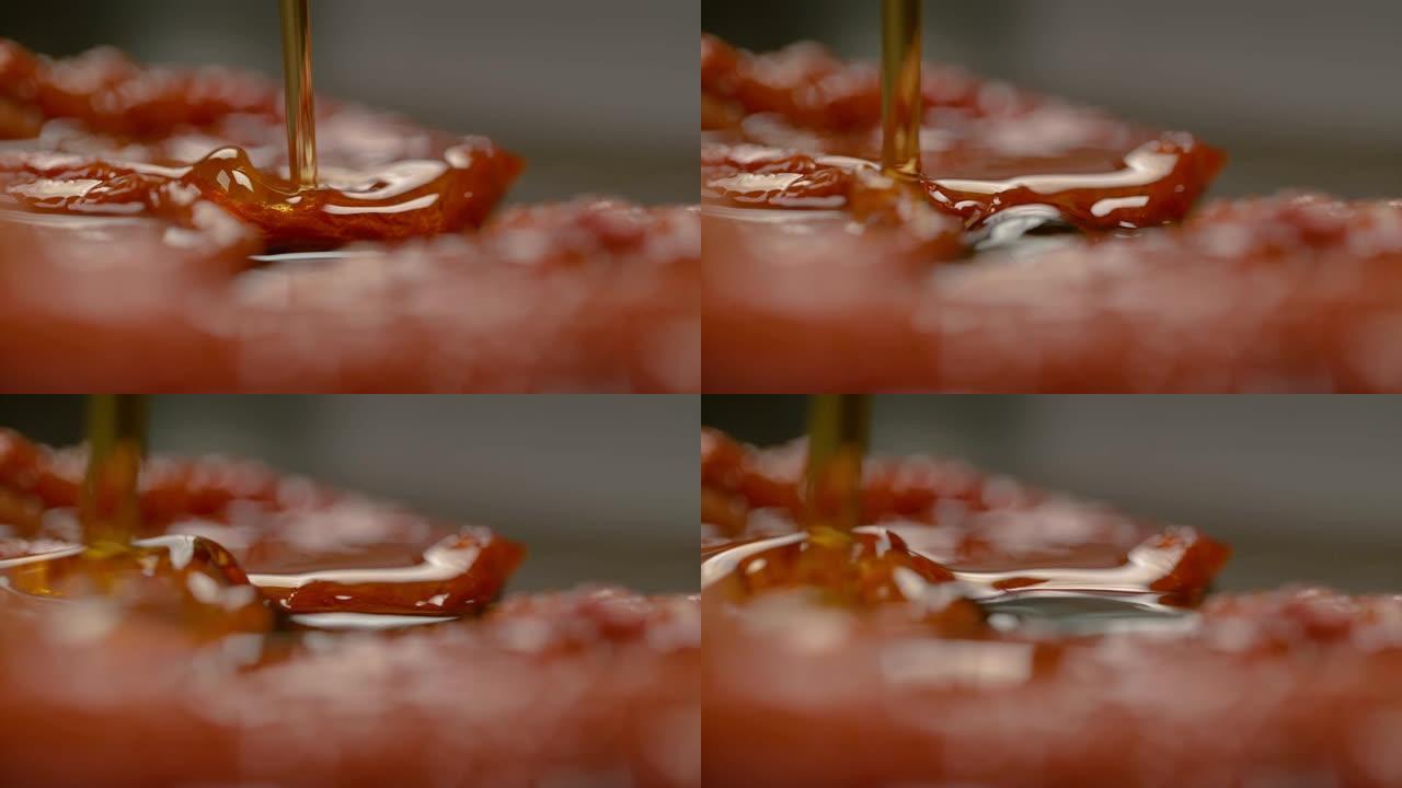 慢动作: 模糊的美味橄榄油溅到腌制的西红柿上。