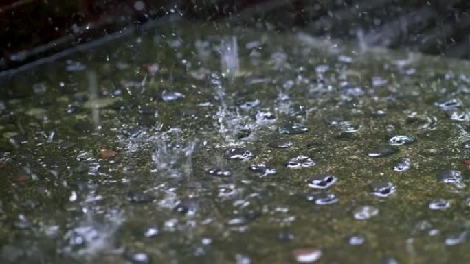 雨滴落在地面上的慢动作镜头，导致水花飞溅。4K, UHD