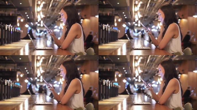亚洲女性在咖啡馆使用智能手机进行社交媒体