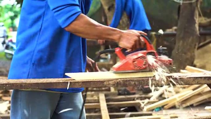 越南东塔丁延亚洲工人用规划机刨削木材的4k镜头，木工工具和机器概念