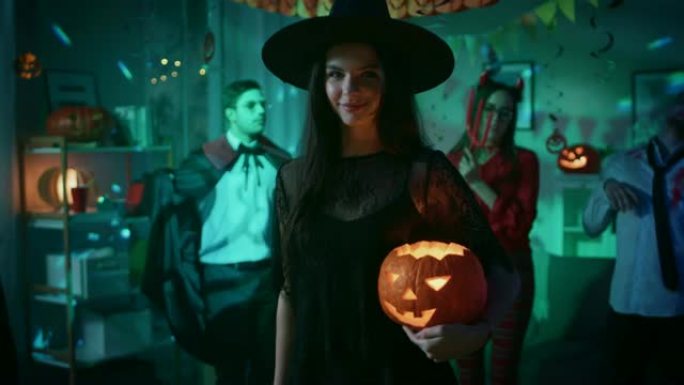 万圣节服装派对: 华丽的女巫穿着礼服拿着燃烧的南瓜，诱人地跳舞。背景: 美丽的她魔鬼，可怕的死亡，德