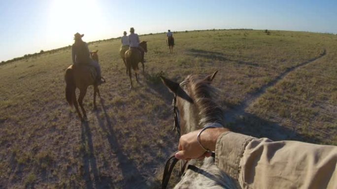 一群骑马者的慢动作视图，他们在Makgadikgadi盐盘的广阔空间中行走