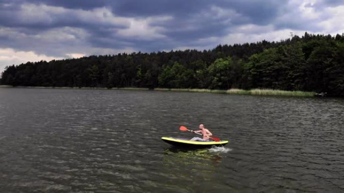在湖上划独木舟。向摄像机挥手