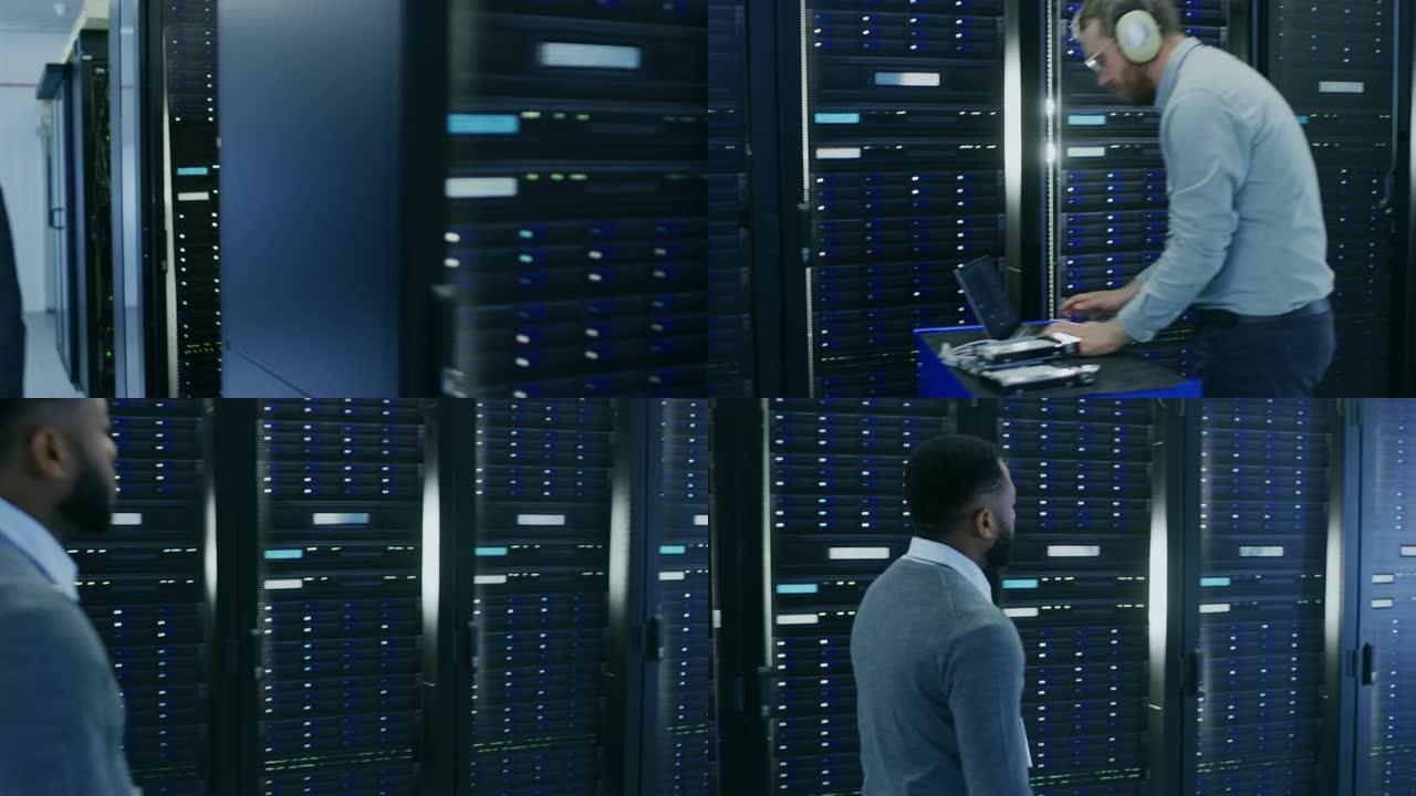 黑人英俊的员工走过数据中心的服务器走廊。他的IT同事正在更换硬盘驱动器，并进行其他服务和维护工作。
