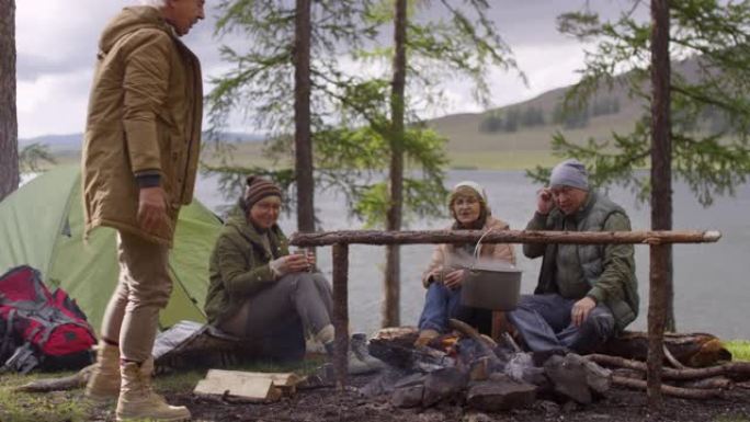 高级游客在篝火旁做饭，喝茶聊天