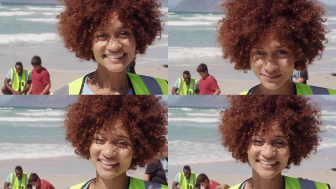 非裔美国女志愿者在海滩上看着相机的前视图4k