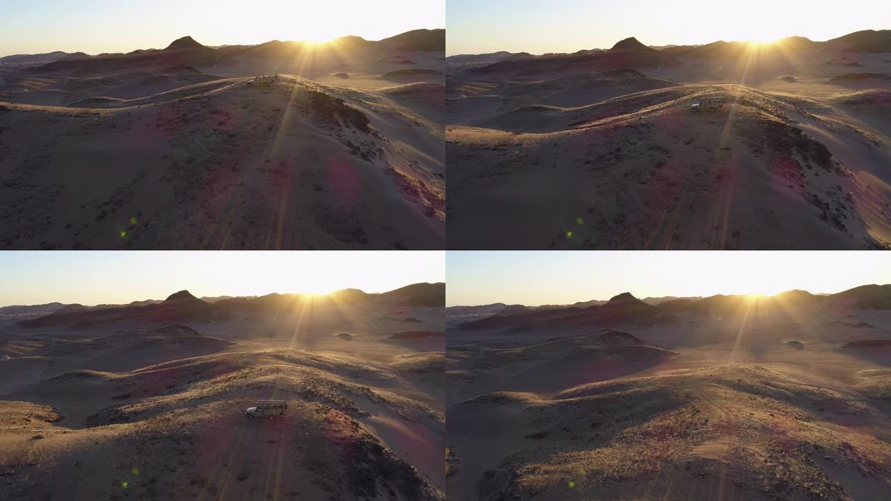 4x4野生动物园车辆的4k鸟瞰图，游客在纳米比亚纳米布沙漠的Hoanib山谷的山上观看日落