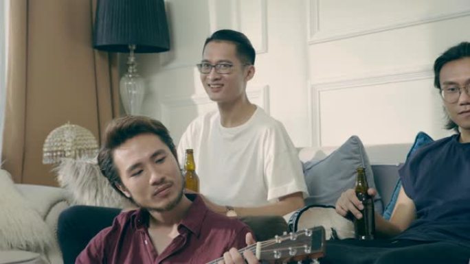 一群年轻的亚洲音乐家聚集在家里喝啤酒