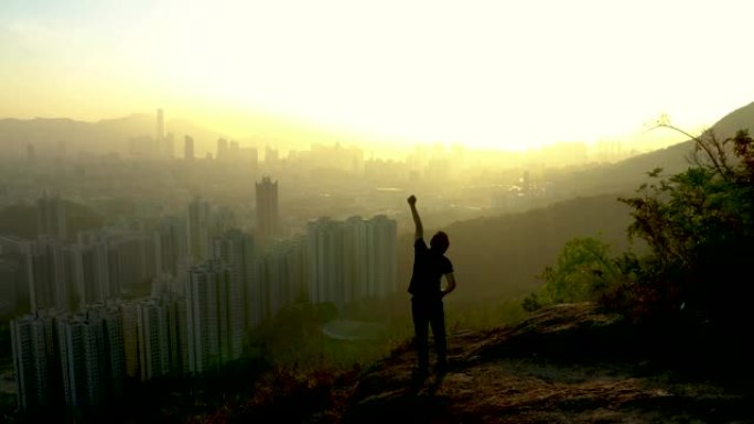 年轻人欢欣鼓舞并举起双手的剪影。成功人士高兴并庆祝山顶上的胜利。商业成功概念。