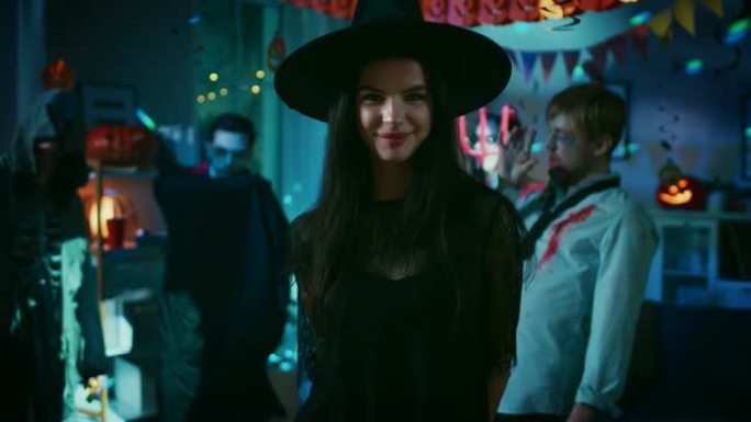 万圣节服装派对: 华丽的年轻女巫穿着礼服和帽子诱人的姿势。背景: 美丽的她魔鬼，可怕的死亡，德古拉伯