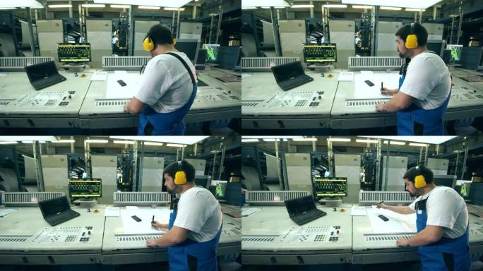 造纸厂，一名男技术员操作控制面板