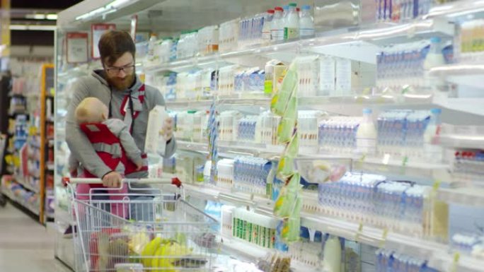父亲带着婴儿在超市买牛奶