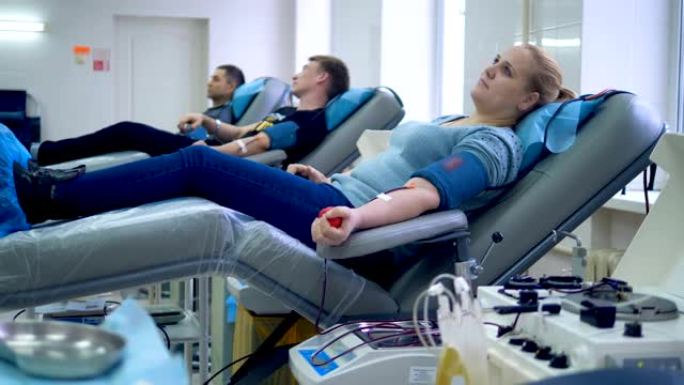 志愿者准备在一个特殊的中心献血，坐在扶手椅上。
