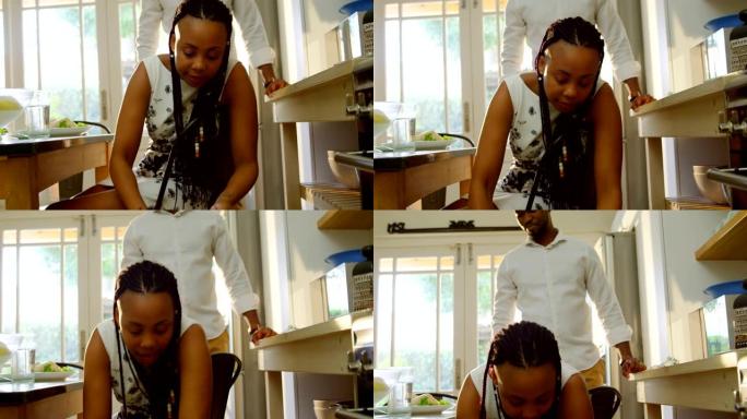 黑人年轻母亲在舒适的家庭4k厨房里给儿子喂饭的前视图