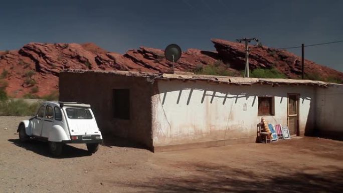 旧的复古车停在阿根廷土坯房的入口处。