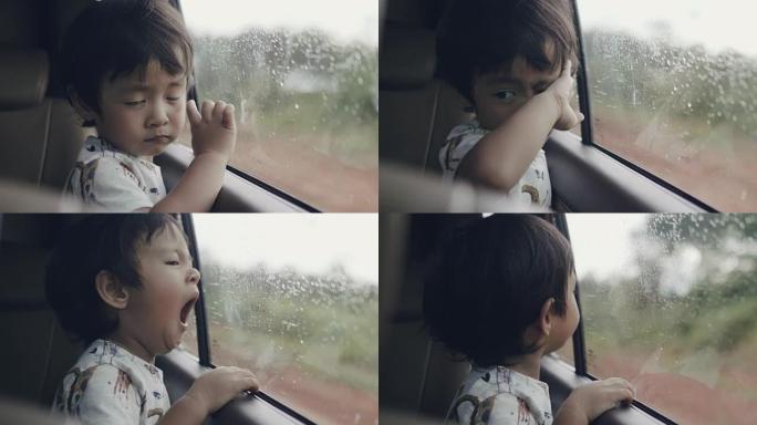 从车窗向外看的小男孩